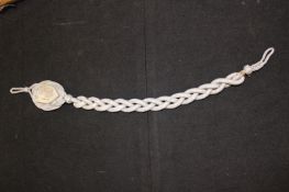 A Third Reich Marksman’s lanyard, braided silver bullion lanyard with stippled alloy eagle and