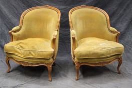 A pair of French Louis XV style tub form armchairs, with moulded carved frames, loose cushions and