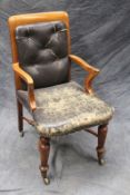 A late Victorian gentleman’s library/office armchair, with ring turned front legs united by