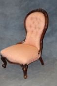 A Victorian spoon back show frame nursing chair, on carved cabriole legs.