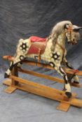 A good early 20th Century dapple grey rocking horse, on iron supports and trestle base.