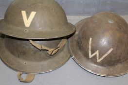 A Second War Northumberland Regiment helmet, together with another similar for a Warden and one