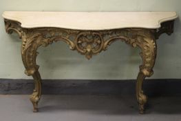 A 19th Century carved giltwood marble topped console table, in the Rococo manner, 146cm wide.