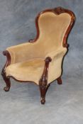 A Victorian mahogany showframe upholstered armchair, of large proportions, with carved decoration on