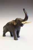 A Japanese Meiji bronze elephant, with raised trunk and ivory tusks, signed under one foot, 17.5cm