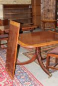 A Regency style mahogany and inlaid twin pedestal dining table, the crossbanded reeded edge top with