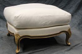 A French Louis XV style carved and gilded low stool, with loose cushion, 72cm square.