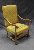 A large 17th Century style carved limed oak armchair, with upholstered high back.