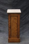 A Victorian satin birch pedestal cabinet, with white marble top, panelled door, on plinth base.