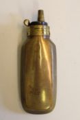 A brass powder flask for a pistol, the flattened rounded rectangular body with gilt brass cap and
