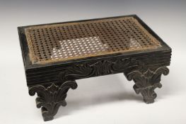 A Regency Colonial carved ebony stool, possibly Ceylonese, with caned top above reeded and foliate