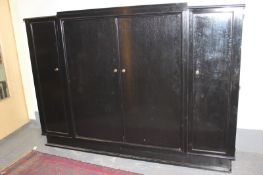 A large early 20th Century French ebonised armoir, with four panel doors, on plinth base, 230cm