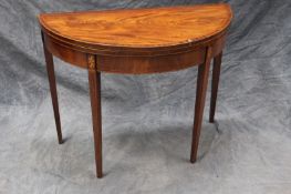 A George III mahogany and inlaid demi-lune card table, with oval fan paterae, on tapering legs, 96cm