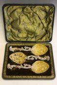 A cased set of three silver gilt fruit serving spoons, by William Comyns & Sons, London 1899, the