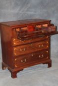 A late Regency mahogany and inlaid secretaire chest, the upper drawer with fall front enclosing