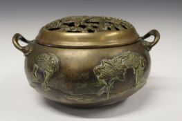 A 19th Century Japanese bronze pot pourri, with cast decoration of cranes in a landscape, the lid