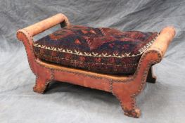 A Liberty style leather upholstered stool, with Afghan carpet upholstered squab cushion.