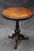 An unusual Victorian rosewood revolving lamp table, with moulded edge top on fluted and carved