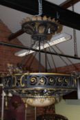 A large Arts and Crafts wrought iron light fitting, with suspended scroll iron basket centred with