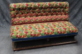 An early 20th Century club sofa, with deep button back, overstuffed seat and waisted plinth base,