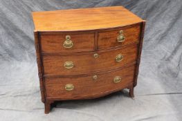 A Regency mahogany bowfront chest of two short and two long graduated drawers, flanked by ring