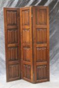 A carved oak three panel floor screen, each with four linenfold panel insets, each panel 183 x 43cm.