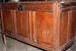 An 18th Century fruitwood coffer, with plank top above triple panel front, on long stile legs, 133cm