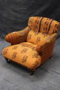 An Edwardian deep seat armchair, with quilted Gundra-Rali upholstery, on short turned forelegs and