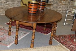 A bespoke large oak drop leaf dining table in 18th Century style, the oval top on baluster turned