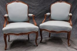 A pair of Louis XV style armchairs, with carved walnut show frames. (2)