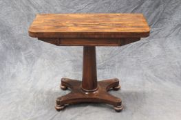 A Regency rosewood foldover card table, on turned tapering column and quadripartite platform base,