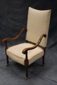 An Edwardian mahogany and inlaid high back armchair, with scroll arms, overstuffed seat and back, on