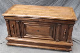 A large 18th Century oak coffer, with plank top above panel front and architectural split turned