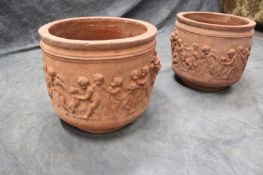 A pair of antique terracotta garden urns, with lion mask mounted handles and cherub decoration,