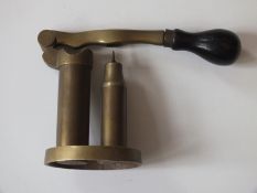 A 14-bore capper de-capper, of brass construction with turned wood handle, stamped 14 to the base.