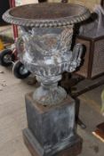 A pair of Victorian cast iron garden urns of classical form, on square plinth bases, 110cm high over