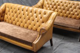 A pair of George I style sofas, each with deep buttoned pale brown leather upholstery, and later