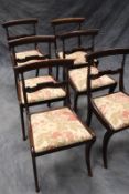 A set of six late Regency dining chairs, each with carved bar back and sabre legs. (6)