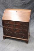 A small George III mahogany bureau, with fitted interior above four graduated long drawers, on