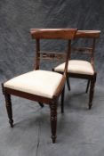 A set of four William IV mahogany dining chairs, each with carved rail back, drop in seat, on turned