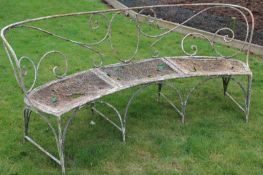 A large wrought iron garden seat of curved form.