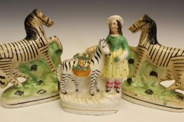 Staffordshire pottery: a pair of zebras, and another of a young girl with a zebra, the largest 16cm.