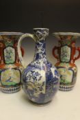 A Japanese blue and white ewer, decorated with panels of landscapes and figures surrounded by