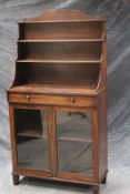 A Regency mahogany chiffonier, with graduated waterfall bookcase above singe drawer and a pair of