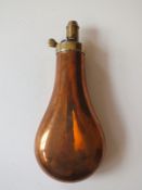 A plain copper powder flask, by Dixon & Sons, graduated nozzle.