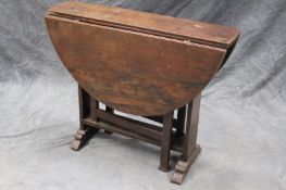 An early 18th Century yew cottage gateleg supper table, on trestle ends with flat stretcher, 97cm