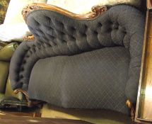 A Victorian Walnut Framed Sofa with arched swept back with carved detail, upholstered in modern dark