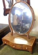 An early 19th Century Dressing Table Mirror, with oval mirror plate, serpentined front with three