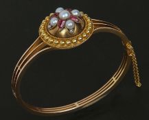 A Victorian Gold Bangle of pierced three band design, featuring a front circular panel with beaded