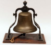 A 19th Century Heavy Bell, constructed from Bell Metal, in a cast and pierced frame on an oak plinth